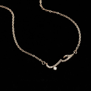 Rose gold Arabic Love necklace with sparkling cubic zirconia on a black background