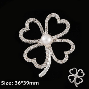 Detailed view of silver clover pin with sparkling rhinestones and a white pearl, 36x39mm