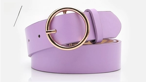 Detail of purple faux leather belt featuring a round gold buckle for fashion jeans