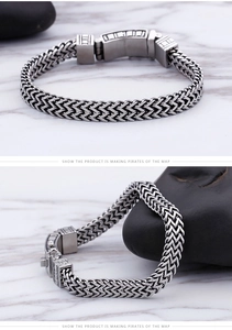 Close-up of a men's double-row woven steel chain bracelet with a vintage textured clasp