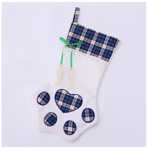 Close-up of dog paw Christmas stocking with blue plaid patterns and fish bone tags
