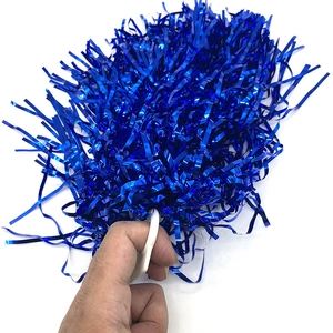 Hand holding a fluffy blue metallic cheerleading pom pom with white handle detail