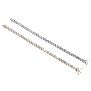 Close-up of gold and silver tennis bracelets with round-cut cubic zirconia and safety clasp