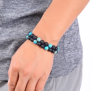 Double-layered bracelet with black lava stone and turquoise beads worn on a male wrist