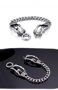 Macro shot of punk skull head and hand claw charms on stainless steel chain bracelet