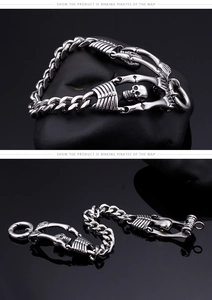 Macro shot of punk skull motifs and vintage titanium steel cuban link bracelet