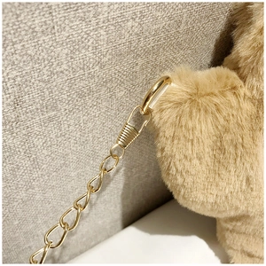 Close-up of golden metal chain strap and soft brown faux fur texture on cat paw bag