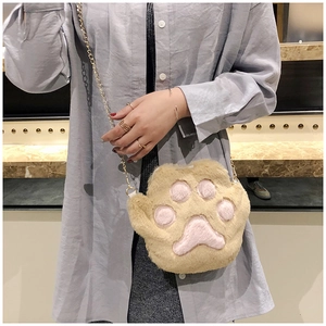 Detail of cute plush cat paw shoulder bag with soft khaki fur and pink embroidery