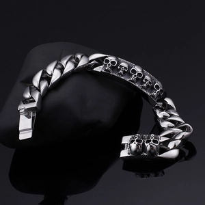 Silver gothic skull bracelet for men with thick Cuban chain on a black stone base