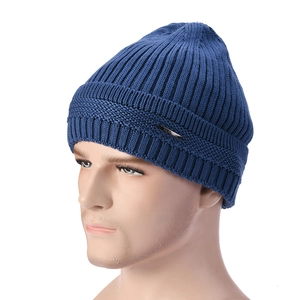 Detailed view of dark blue ribbed knit beanie featuring a classic metal emblem