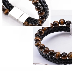 Detail of tiger eye stone beads and black braided leather bracelet with magnetic clasp