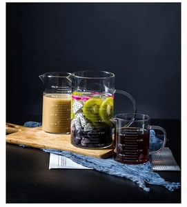 Three heat-resistant glass measuring cups in 350ml, 500ml, and 1000ml sizes on a rustic table