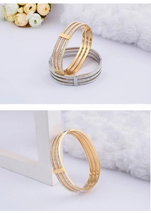 Close-up of triple-layer hollow bracelets in gold and silver with sparkling rhinestones