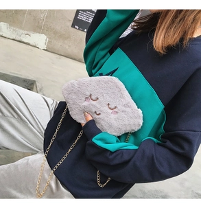 Detailed view of grey cloud-shaped plush bag with embroidery and gold chain strap