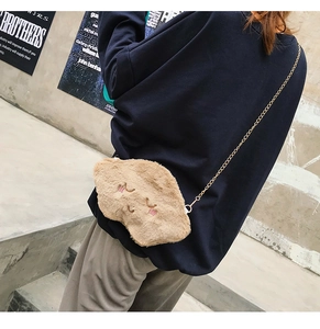 Detail of embroidered plush cloud bag in khaki with a gold chain strap on a model