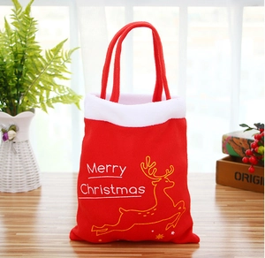 Détail du sac de Noël en velours rouge avec renne doré et texte Merry Christmas