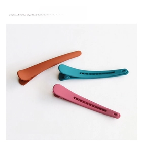 Detail view of colorful matte hair clips in orange, cyan and rose pink Morandi tones