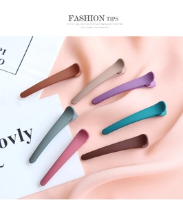 Close-up of matte duckbill hair clips in seven trendy colors on silk background
