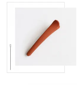 Detail view of matte brick red acrylic hair clip with a smooth minimalist texture