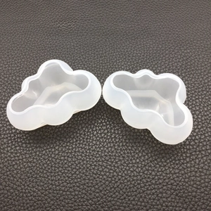 Detail of two-piece semi-transparent cloud-shaped silicone molds on grey textured surface