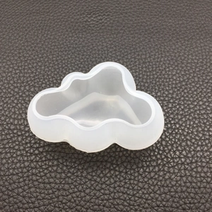 Macro detail of a 3D cloud silicone mold for resin and candle making on leather background