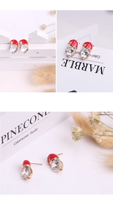 Detail view of snowman hat earrings with red enamel and sparkling zircon crystal inlay