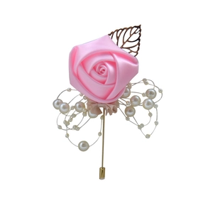 Detail of pink silk rose boutonniere with white pearls and a golden hollow leaf