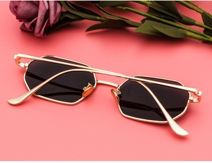 Detail of vintage rectangular metal sunglasses with gold frame and black lenses