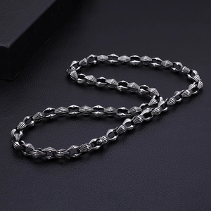 Bold punk style stainless steel chain necklace for men on a black textured background