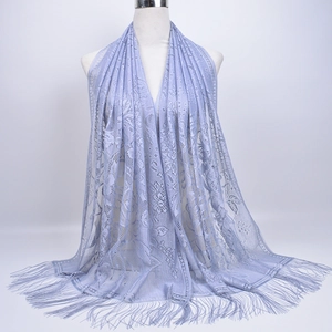 Close-up of light purple lace scarf featuring intricate floral hollow patterns and long tassels