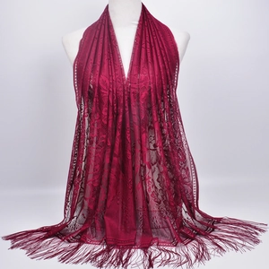 Close-up of deep red lace shawl with intricate hollow patterns and elegant fringe details