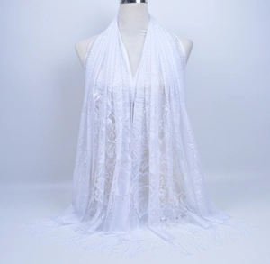 Detailed view of white floral lace scarf with fringe trim on a mannequin bust