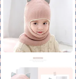 Detailed close-up of pink knit baby balaclava with cute grey cat ears for winter warmth