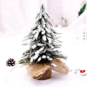 Miniature snow-flocked Christmas tree with rustic burlap base for tabletop decoration