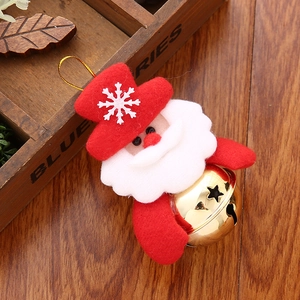 Détail d'un pendentif Père Noël avec une grande cloche dorée et un bonnet rouge festif
