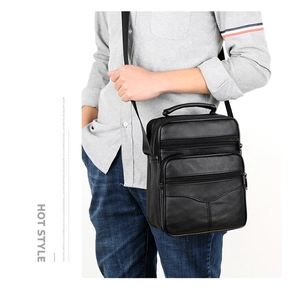 Men's black leather crossbody bag with multiple zipper pockets shown on model