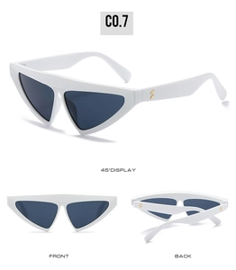 Detail view of white triangle sunglasses featuring golden oval accents and dark lenses