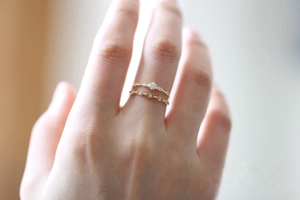 Close-up of stacked 14K gold plated silver rings featuring delicate pave set diamonds