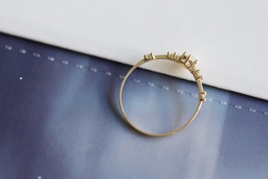 Macro detail of slim 14K gold-plated S925 silver ring featuring V-shaped diamond accents