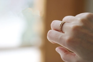 Close-up of a slim 14K gold plated silver ring with seven small zircon stones on a model hand