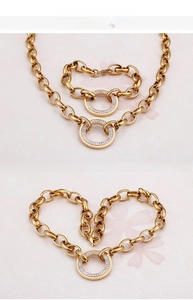 Detailed view of chunky gold chain jewelry set with pave crystal ring pendant