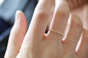 Detail of s925 silver 14K gold ring with seven sparkling cubic zirconia stones on finger