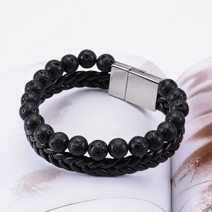 Macro shot of double-row lava stone beads and braided leather bracelet with magnetic clasp