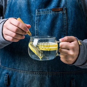 Tasse en verre thermorésistant Good Morning avec anse et cuillère tenue par des mains