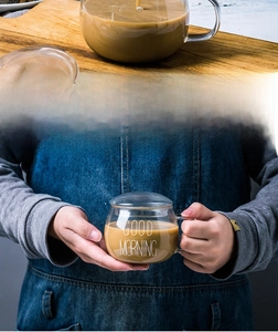 Gros plan d'une tasse à déjeuner en verre thermorésistant avec couvercle et logo