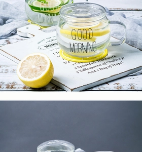 Gros plan d'une tasse en verre Good Morning avec citrons sur planche en bois blanc
