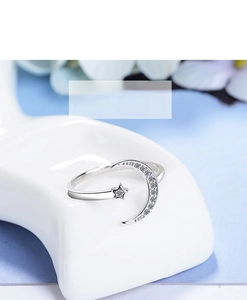 Detail of adjustable silver ring featuring sparkling zircon moon and star motifs