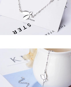 Detailed close-up of a silver butterfly charm bracelet with mirror-polished finish