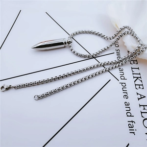 Collier à pendentif balle argentée avec chaîne boîte en acier sur fond minimaliste