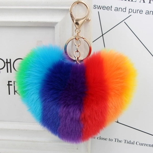 Rainbow heart faux fur keychain with gold ring pendant on a minimalist white frame